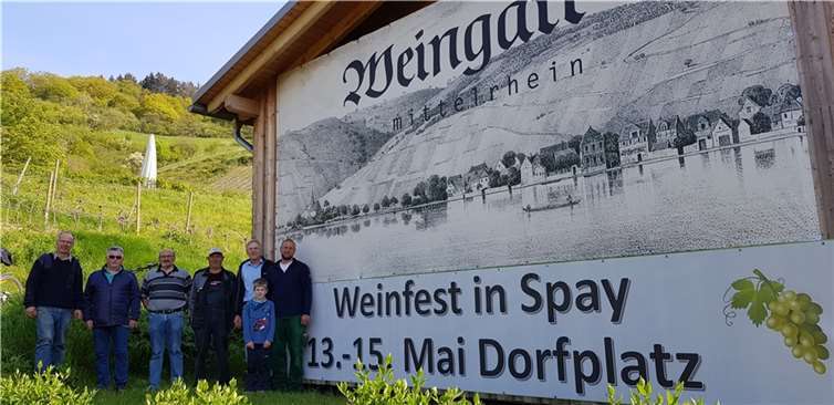 Das Organisationsteam und Helfer (v.l. Matthias Müller, Walter Gräf, Herbert Kasper (Feuerwehr), Franz Werner Schweikert, Wolfgang Paul (Förderverein), Florian Weingart eröffnen die Werbekampagne für das Weinfest mit einem Plakat an der Halle des Weingutes Weingart im Bopparder Hamm. Die Festzeitschrift wird an alle Spayer Haushalte verteilt. Foto: privat