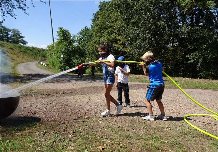 Das Strahlrohr bedienen die Kinder gemeinsam – wie es auch die Großen im Einsatz tun.