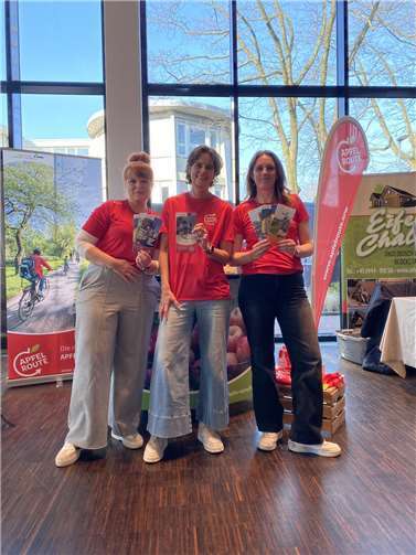 Das Team des RVT (v.l.n.r.): Beate Hinz, Katrin Jürgensen und Luana Schüller mit den neuen Apfelroutenkarten. Foto: Rhein-Voreifel Touristik e.V.