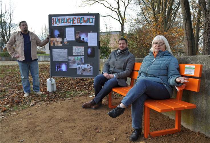 Das Thema „Häusliche Gewalt“ macht eine neue orangefarbene Bank sichtbar. Giuseppe Marina, Tobias Pötzsch und Bettina Hihn (von links) informierten über die Aussagekraft des Sitzmöbels.Foto: Stadt Meckenheim