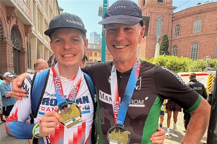 Das Vater- und- Sohn -Duo, Jörg (re) und Niklas Schütz trotzen den Hitzebedingungen beim Ironman in Frankfurt! Beide präsentieren stolz ihre Finisher Medaille am Frankfurter Römer