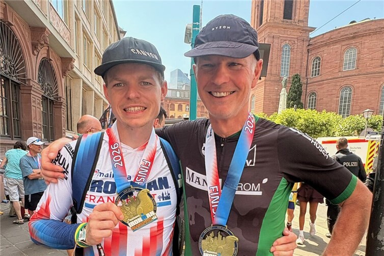 Das Vater- und- Sohn -Duo, Jörg (re) und Niklas Schütz trotzen den Hitzebedingungen beim Ironman in Frankfurt! Beide präsentieren stolz ihre Finisher Medaille am Frankfurter Römer.
