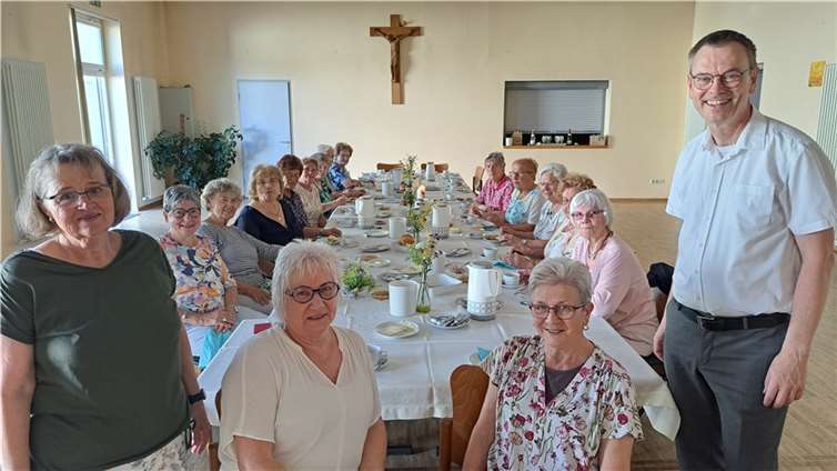Das Vorstandsteam Marita Schneichel, Marita Krämer, Maria Eube und Hiltrud Hillesheim mit ihrem Pastor Norbert Missong und einigen Frauen im zum Frühstücksraum liebevoll gestalteten Pfarrsaal.  Foto: Marion Bast