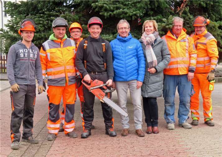 Das „Weihnachtsbaum-Team“ mit den Baumspendern vor der hängenden Tanne.