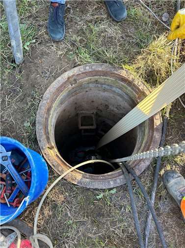 Das breite Kunststoffband wird in den Schacht eingeführt. Unten entsteht durch spiralförmiges Wickeln ein neues Rohr im alten Rohr. Das Verfahren ist kostengünstiger und umweltfreundlicher als die herkömmliche offene Bauweise.