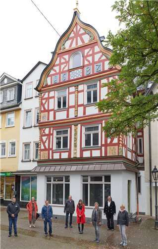 Das frisch sanierte Fachwerkhaus am Kleinen Markt hat eine besonders reich geschmückte Fassade. Ein echter Hingucker. Davor traf sich die Arbeitsgruppe Fachwerkstraße zum Fototermin mit Stadtbürgermeisterin Gabi Wieland (2.v.l.), Tourismusbeauftragten Karin Maas (5.v.l.) und Zimmermann Thomas Becker (7.v.l.). Foto: Stadt Montabaur / Olaf Nitz