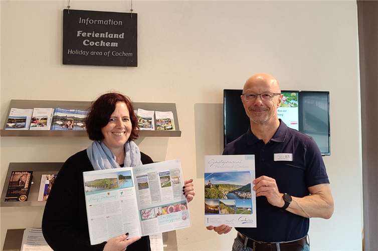 Das neue Gästejournal 2026 ist seit Anfang Oktober 2025 verfügbar. Der Leiter der Tourist-Information Ferienland Cochem, Harald Bacher, sowie Projektkoordinatorin Daniela Kruse halten das Urlaubsmagazin bereits in ihren Händen. Foto: Tourist-Information Ferienland Cochem