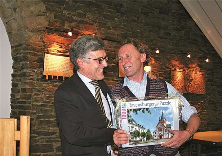 Das passende Geschenk für einen, der im „Haus des Bares“ wohnte: Der Bürgermeister überreicht dem Künstler ein Sinzig-Puzzle mit Kirchplatzblick.