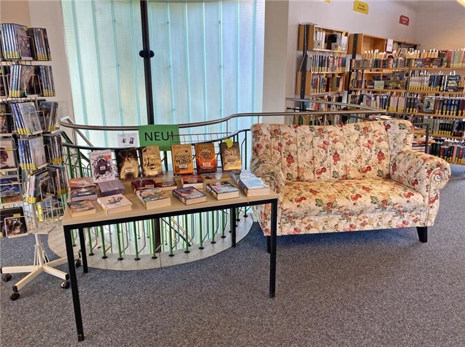 Das passt zusammen: Auf dem Sofa neben den neuen Romanen kann die Bücherbrücken-Leserschaft schon mal „anlesen“. Foto: Stadt Meckenheim