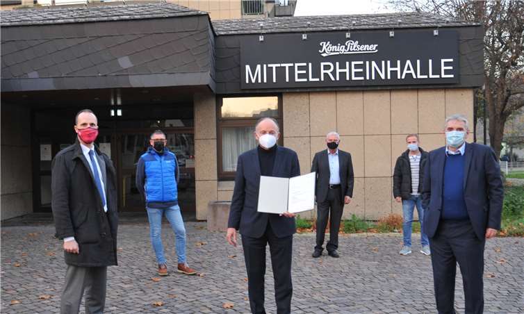 Das rheinland-pfälzische Innenministerium fördert die Sanierung der Mittelrheinhalle mit insgesamt 1,2 Millionen Euro. Den entsprechenden Bewilligungsbescheid hat der Chef der Staatskanzlei, Staatssekretär Clemens Hoch (links), jetzt Andernachs Oberbürgermeister Achim Hütten (3. von links) überreicht. Darüber freuen sich auch Bürgermeister Claus Peitz (rechts) sowie Bodo Neunheuser (2. von links), Amtsleiter Rainer Schmitz und Markus Umbscheiden (2. von rechts) vom städtischen Bauamt.Foto: Stadt Andernach/Maurer