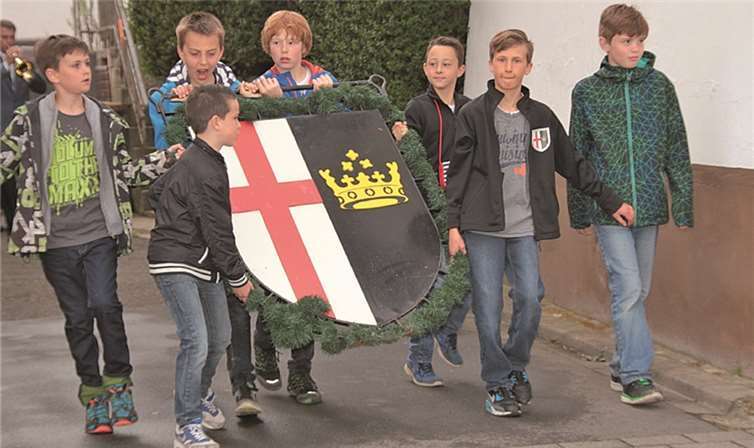 Das schmiedeeiserne Ortswappen wird von der Kirmesjugend zum Kirmesbaum getragen. -AND-