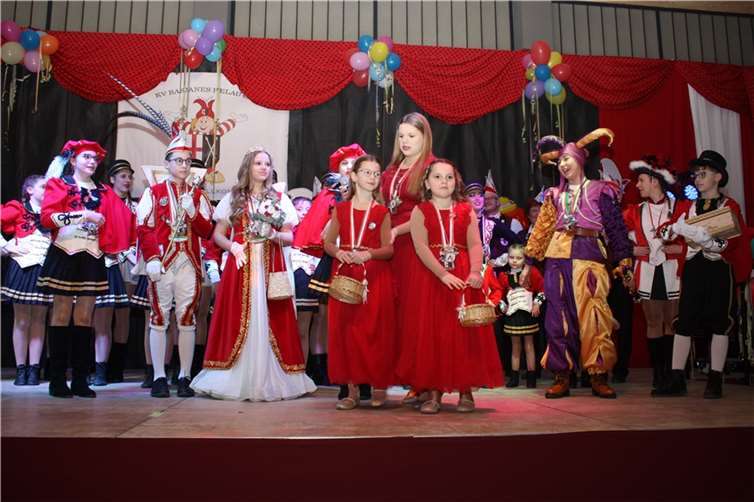 Das vereinseigene Kinderprinzenpaar Prinzessin Leni I. und Prinz Nils I. samt Hofstaat wurden in der sehr schön geschmückten Halle jubelnd empfangen und komplettierten das bunte Vereinsbild auf der Bühne. Quellen: KV Basjanes Helau