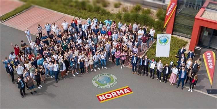 Daumen hoch für eine nachhaltige Zukunft: NORMA-Mitarbeitende und die Geschäftsleitung versammelten sich zur Übergabe des Zertifikats von GREEN BRAND vor dem Unternehmenssitz in Fürth. Foto: NORMA