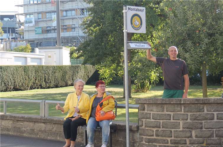 Daumen hoch wie beim Trampen heißt: „Ich möchte mitgenommen werden.“ (v.l.) Stadtbürgermeisterin Gabi Wieland, Generationenbeauftragte Judith Gläser und Betriebsleiter Christoph Kuhl vom städtischen Bauhof nehmen die neue Mitfahrerbank an der Peterstorstraße in Betrieb. Foto: VG Montabaur