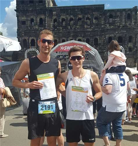 David Simon und Matthias Zucchet nach ihren starken Halbmarathon-Läufen beim Trierer Stadtlauf mit Urkunden vor der Porta Nigra .privat