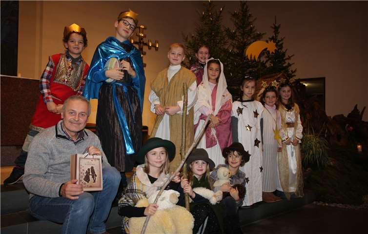 Dekanatskantor Peter Uhl mit den Darstellern des Krippenspiels. Foto: Christoph Kirst