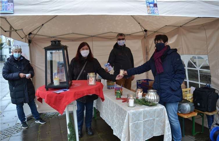 Dekanatsreferentin Andrea Kien-Groß (rechts) überreicht das Licht an eine Besucherin. Mit auf dem Bild sind Marion Eisler und Pfarrer Dr. Arno-Lutz Henkel. Foto: E.T. Müller