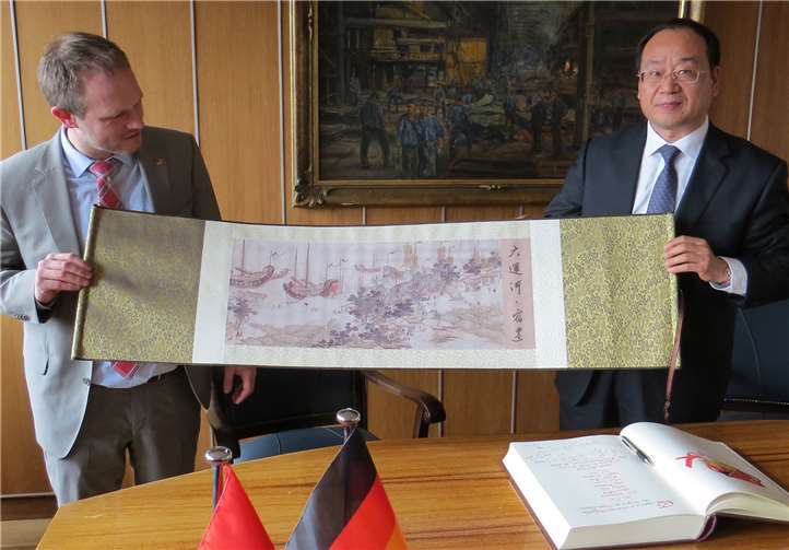 Delegationsleiter Xu De überreichte Oberbürgermeister Jan Einig ein Seidenbild mit einer alten Ansicht Suqians. privat