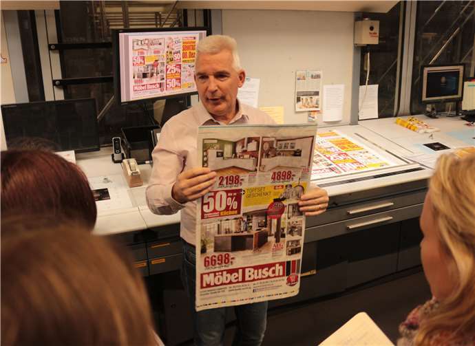 Dem Team der Schülerzeitung wird eine Beilage gezeigt, bevor sie zugeschnitten und gefalten in der Zeitung liegt.