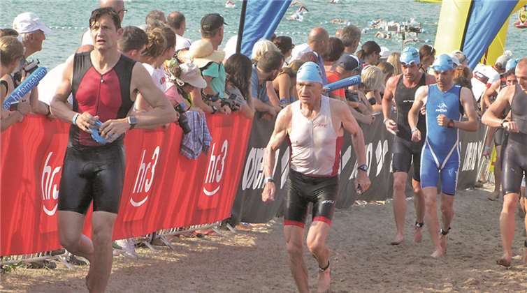 Den 75-jährige Jochen Sackel (Mitte) von der LG Heimerzheim beim Schwimmausstieg.privat