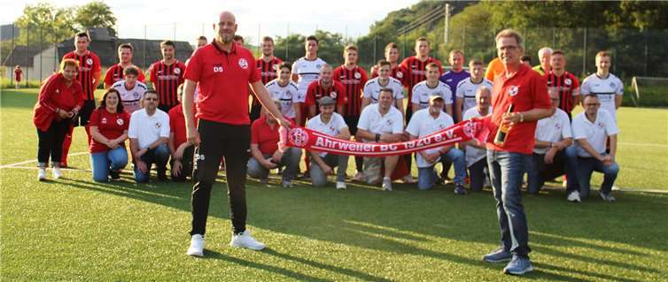 Denis Schäfer vom BC Ahrweiler überreichte dem 2. Vorsitzenden Thomas Siebert des FV Erpel einen Fan-Schal und eine Flasche Flut-Wein. Im Bild sind beide Mannschaften und der FVE-Fanclub vor dem Spiel. Foto: privat