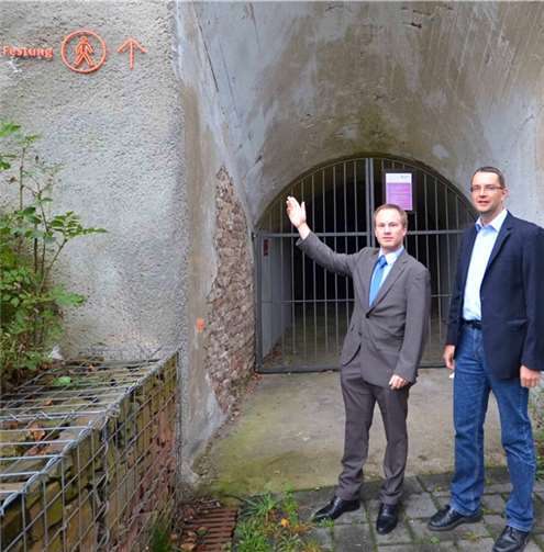 Dennis Maxeiner (l.) und Dirk Mettler (r.) zeigen es an: Der Hinweis zur Festung ist gut erkennbar. Jedoch sind die Tore des Felsenbunkers verschlossen.privat