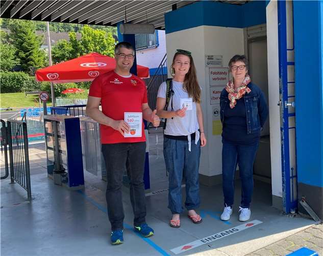 Dennis Swirsky und Barbara Weber übergaben den Hauptgewinn vor dem Eingang des Linzer Schwimmbads.  Foto: Christina Leis