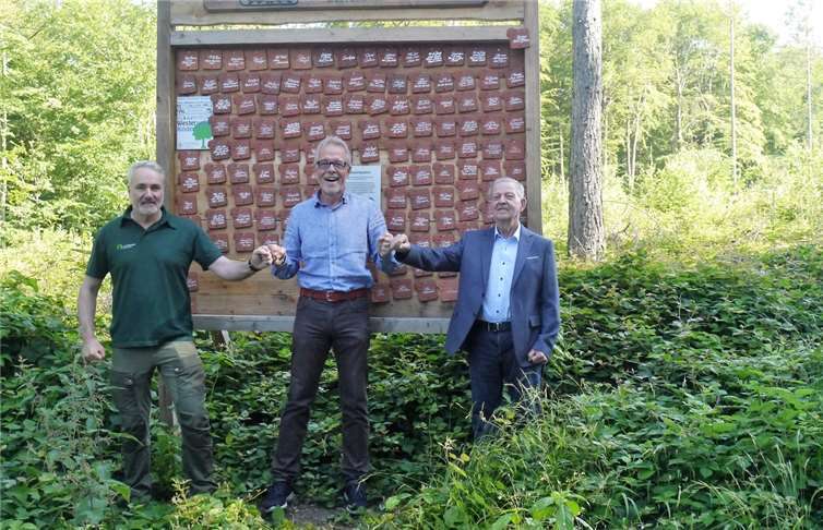 Der 1. Beigeordnete der Ortsgemeinde Hillscheid, Gerhard Schmidt, Joachim Türk vom Kinderschutzbund und Förster Bernd Nückel (v.r.) besiegelten symbolisch den Vertrag über die Zusammenarbeit der Gemeinde mit den „Westerwald-Kindern“. An der Baumpatentafel, gleich neben dem Wanderparkplatz, überbrachte Joachim Türk die gute Nachricht, dass es dank immer noch zahlreicher Spenden möglich ist, in Hillscheid zusätzlich zu den bereits gepflanzten 1000 Eichen weitere 500 zu finanzieren.Foto: privat
