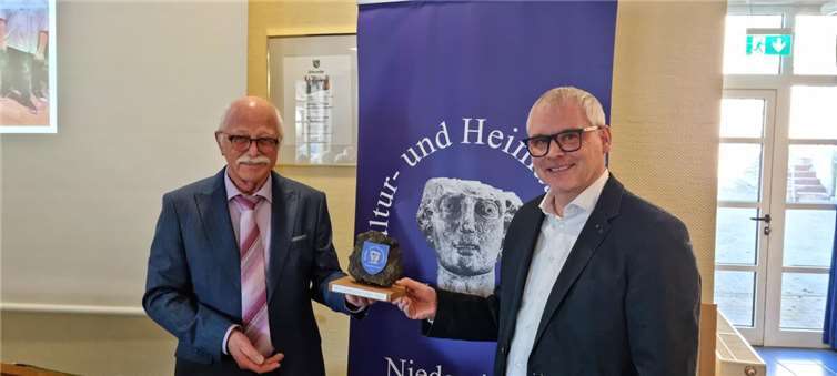 Der 1. Vorsitzende Richard Keuler übergibt den „Krotzen“ des Kultur- und Heimatvereins Niederzissen an Timo Djelassi.  Foto: POE