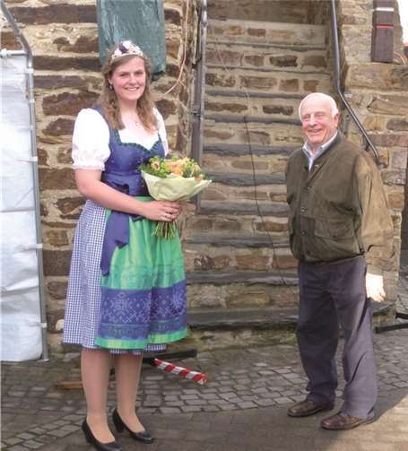 Der 1. Vorsitzende der Bürgergemeinschaft, Erwin Schumacher, begrüßtdie Bachemer Weinkönigin Jennifer Schwab mit einem Blumenstrauß.D. Simom