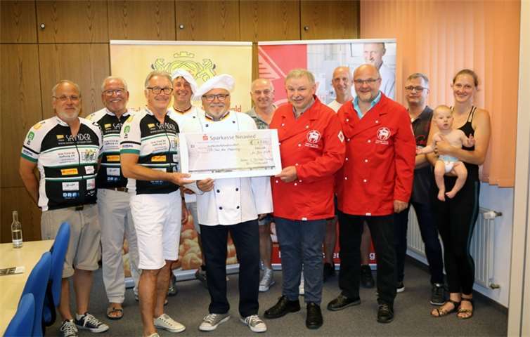 Der 1. Vorsitzende der Hilfsaktion, Jürgen Grünewald, nahm den Spendenscheck von den Obermeistern Thomas Christian (Fleischer-Innung Rhein-Westerwald) und Hubert Quirmbach (Bäcker-Innung Rhein-Westerwald) im Beisein von an der Veranstaltung beteiligten Bäckern und Fleischern entgegen.Foto: privat