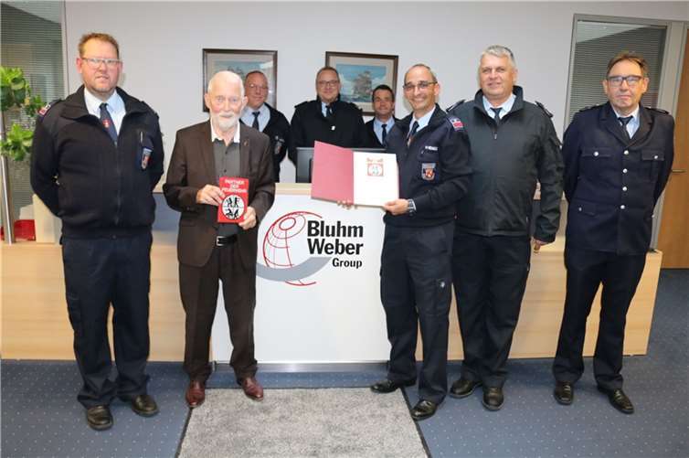 Der 1. Vorsitzende des Kreisfeuerwehrverbands Neuwied, Walter Eudenbach, überreichte Firmengründer Eckhard Bluhm im Beisein der Wehrleitung, Wehrführung und Feuerwehrangehörigen die Urkunde und das Förderschild. Foto: Firma Bluhm