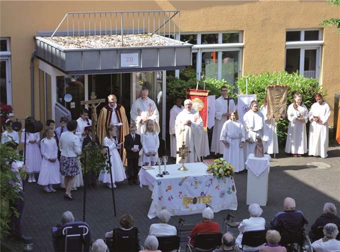 Der Altar an der Seniorenresidenz mit den Geistlichen, Messdienern und Kommunionkindern. AB