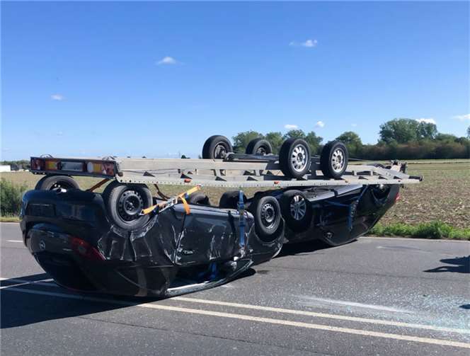Der Anhänger mit beiden Pkw trennte sich vom Zugfahrzeug und kam auf dem Dach liegend zum Stillstand.  Foto: Kreispolizeibehörde Euskirchen