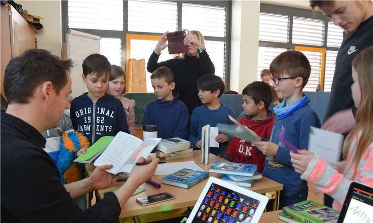 Der Autor Björn Berenz bestaunt die Werke der Nachwuchs-Autoren. Fotos: -UBU