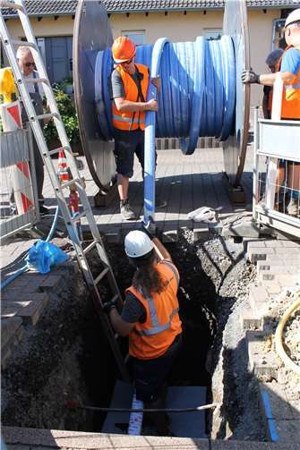 Der Blick in die Baugrube zeigt, wie der Inliner von der Rolle gezogen und in die alte Leitung gefädelt wird.