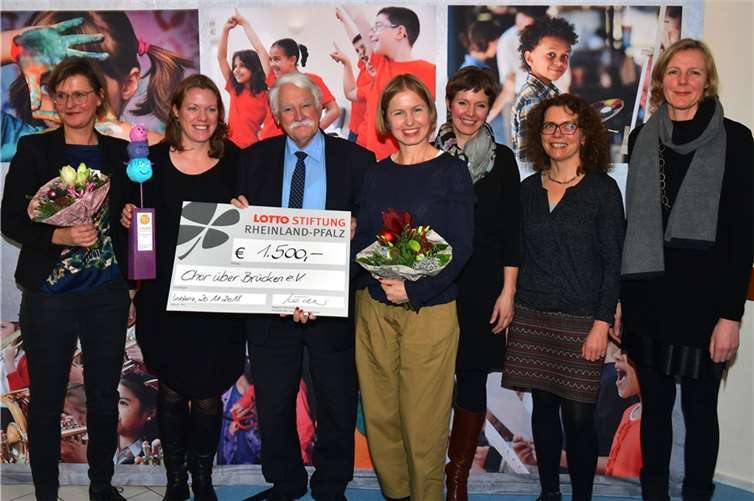 Der „Chor über Brücken“ aus Trier wurde mit dem dritten Preis geehrt. Aus den Händen von Teneka Beckers (Geschäftsführerin der Tuchfabrik Trier, links) und Walter Desch, Vorstandsmitglied der LOTTO-Stiftung (3.v.l.) erhielt die Delegation des Chores aus Trier den Preis. Unter anderem dabei: die Chorleiterin Julia Reidenbach (2.v.l.) und die 1. Vorsitzende Katrin Hintzen (3.v.r.).