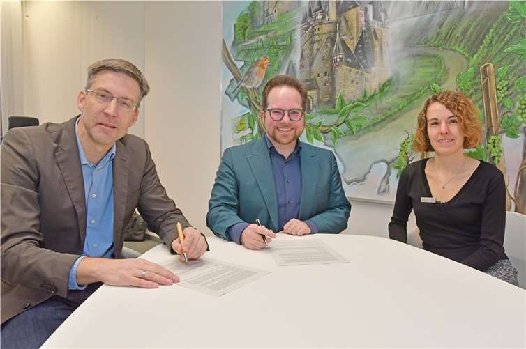 Der Erste Kreisbeigeordnete Pascal Badziong (Mitte) gemeinsam mit Sonja Gröntgen, Leiterin der Smarten Region MYK10, und dem Kooperationspartner Christian Schmitt bei der Vertragsunterzeichnung im Kreishaus.  Foto: Kreisverwaltung/D.Morcinek