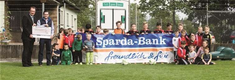 Der Erste Vorsitzende des TuS, Andreas Müller, nahm die Spende von Henning Oster entgegen und freut sich mit den kleinen Fußballern über diese Unterstützung. privat