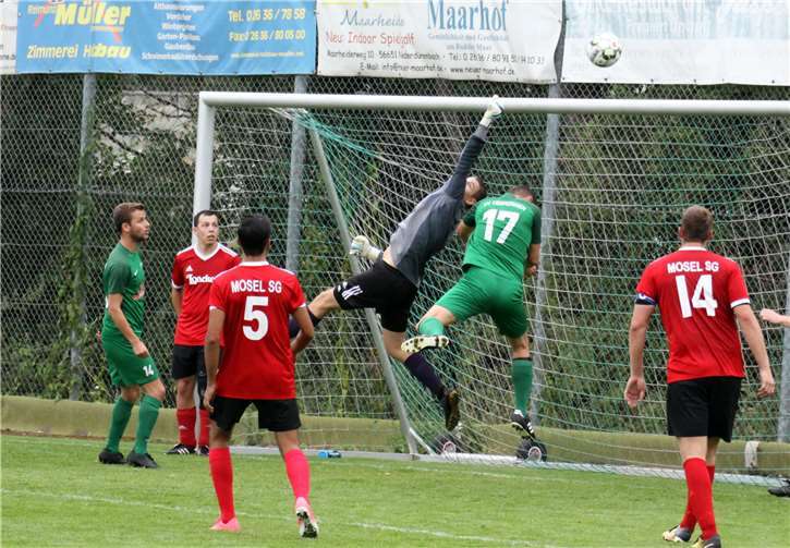 Der Gästetorwart bewahrte seine Mannschaft mehrmals mit tollen Paraden vor einer höheren Niederlage, hier bei einem Kopfball von Richard Denkhaus (grünes Trikot).Claus Deptalla