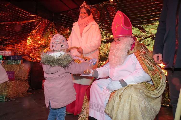 Der Heilige Nikolaus beschenkt Kinder.