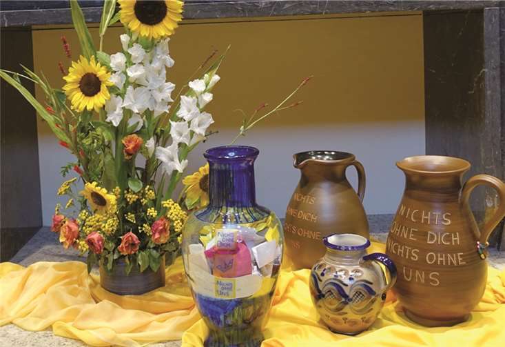 Der Inhalt der gefüllten Krüge wird in einem Feuerbecken bei Gesängen internationaler Lieder verbrannt.