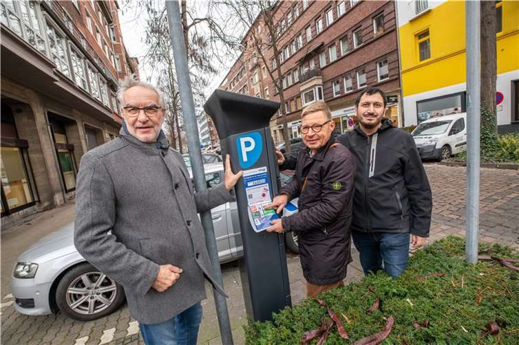Der Koblenzer Baudezernent Bert Flöck (links) und Hakan Aksu (rechts, Projektleiter Handyparken bei der Stadt Koblenz), brachten gemeinsam mit Guido Breitenbach von smartparking den ersten Aufkleber für das ab 1. Januar 2024 eingeführte Handyparken in Koblenz an.  Fotos: Stadt Koblenz/Andreas Egenolf