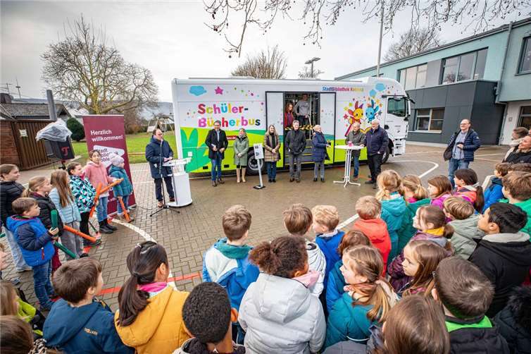 Der Koblenzer Bildungs- und Kulturdezernent Ingo Schneider (am Mikrofon) konnte zur Premiere des neuen Schülerbücherbus in Koblenz hatte an der Grundschule Güls zahlreiche Kinder, Lehrer, Eltern und Vetreter aus der Politik und von Sponsoren begrüßen.  Fotos: Stadt Koblenz/Andreas Egenolf