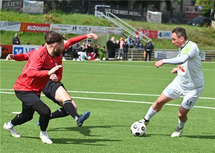 Der Mendiger Damir Mrkalj (rechts) nimmt es gleich mit zwei Akteuren des FV Rübenach (links Alexej Eberhardt) auf.  Foto: SK