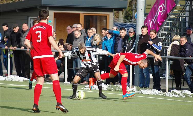 Der Mendiger John Rausch (Mitte) räumt den Morbacher Kapitän Heiko Weber geradezu aus dem Weg. Links sieht Webers Mannschaftskollege Matthias Haubst zu.