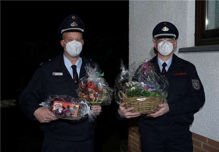 Der Neu-Wehrführer Mario Piovesan zusammen mit Alt-Wehrführer Christoph Teuner mit den Präsenten für dem Haus von Martin Homscheid.