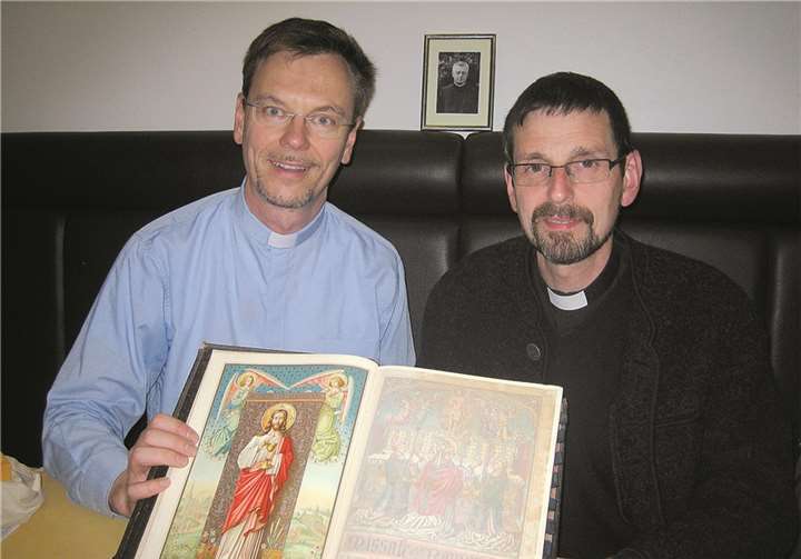 Der Nickenicher Pfarrer Norbert Missong und der Elmer Pfarrer Hans-Georg Müller mit dem Messbuch von Pfarrer Johannes Schulz, der qualvoll im Konzentrationslager Dachau starb und als Glaubenszeuge verehrt wird. privat