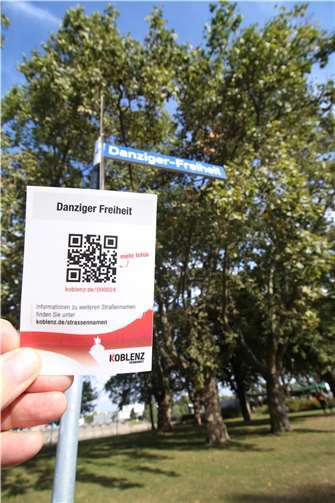 Der QR-Code-Aufkleber der „Danziger Freiheit“ im Vordergrund, das Straßenschild im Hintergrund.Quelle: Stadt Koblenz