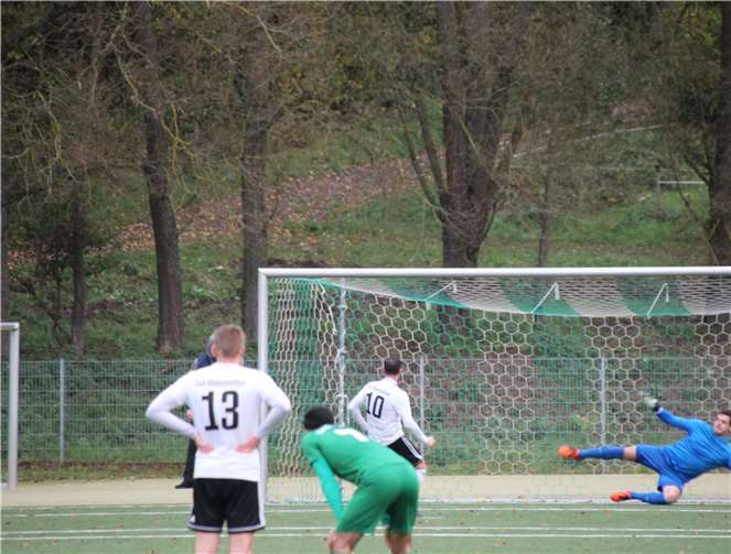 Der Rheinböllener Andreas Herdt (10)bezwingt TuS-Keeper Benjamin Kauert mit einem Strafstoß.Marcel Held (13) und Mussa Mumini (7) blicken gebannt zu. Foto: Sven Lohe.